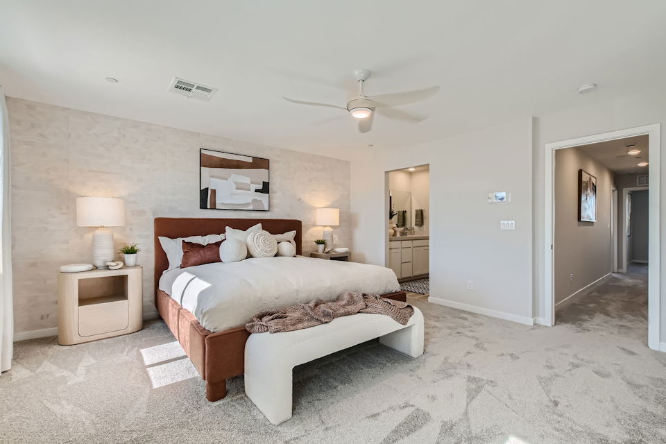 A bedroom with a bed and lamps.