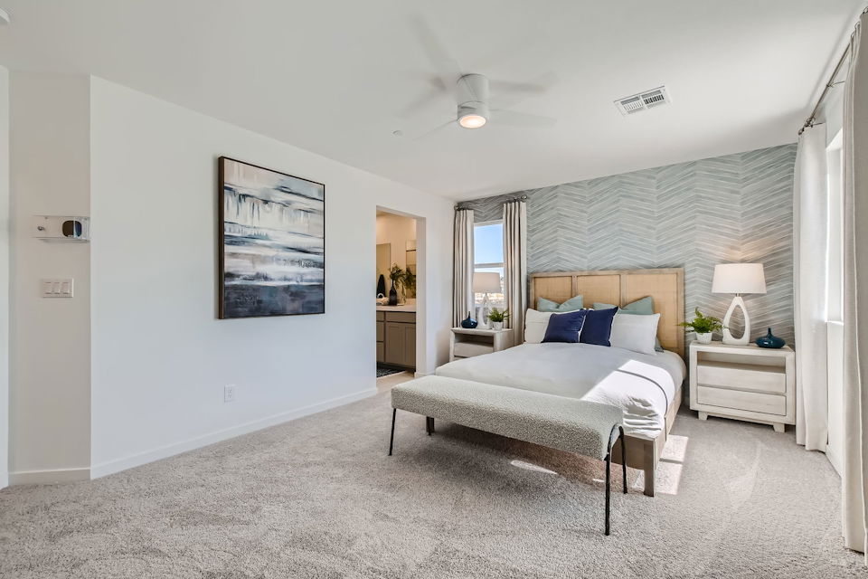 A bedroom with a bed and a lamp.