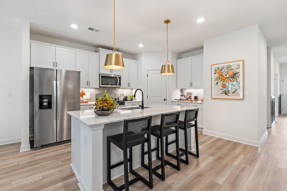 A kitchen with a dining table and a refrigerator.