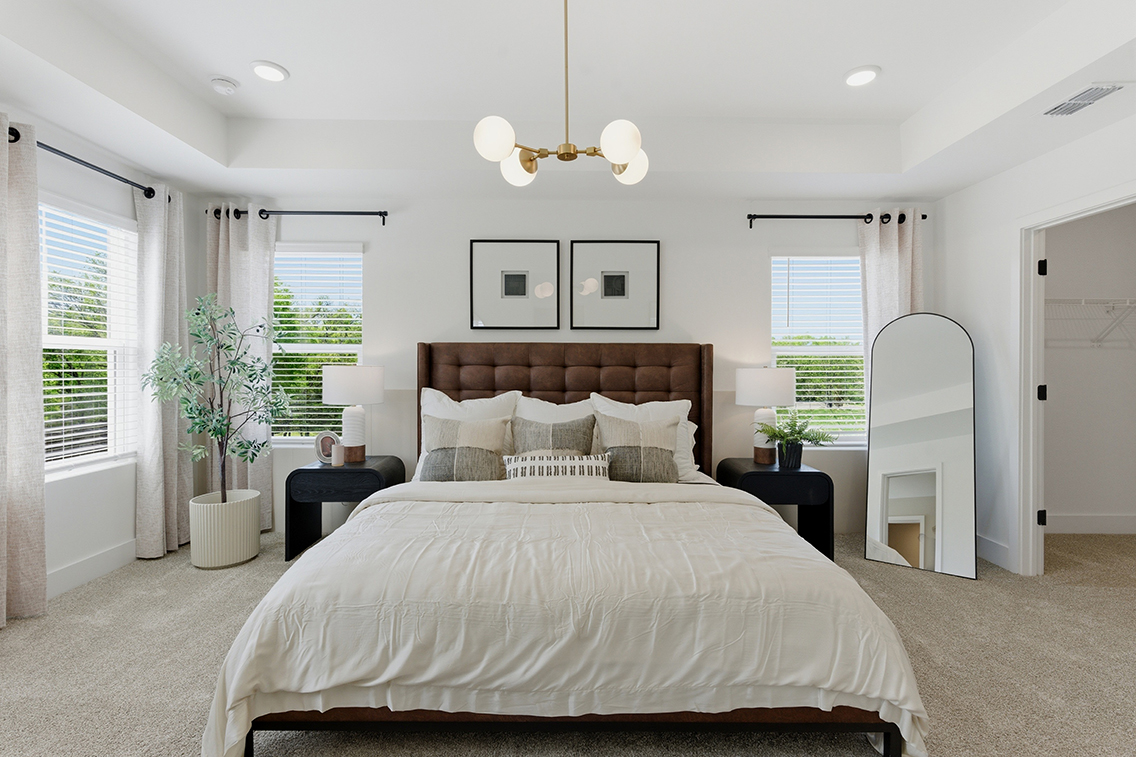 A bedroom with a bed and a chandelier.