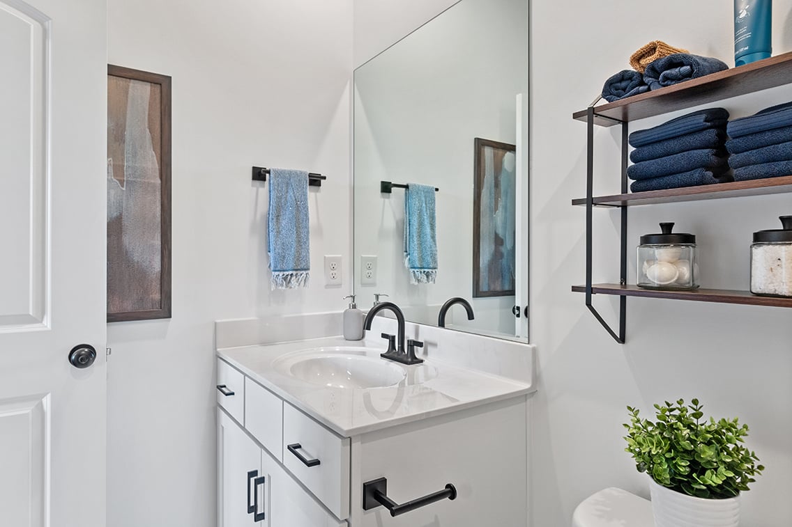 A bathroom with a sink and shelves.