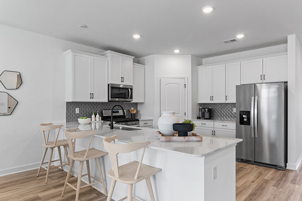 A kitchen with white cabinets.