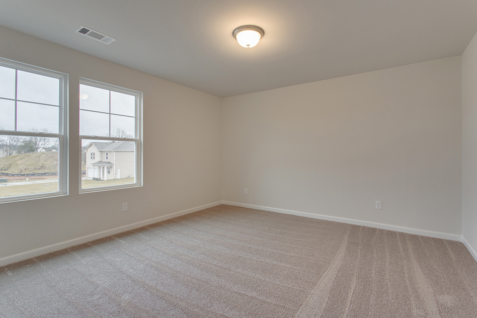 A room with a carpet and windows.
