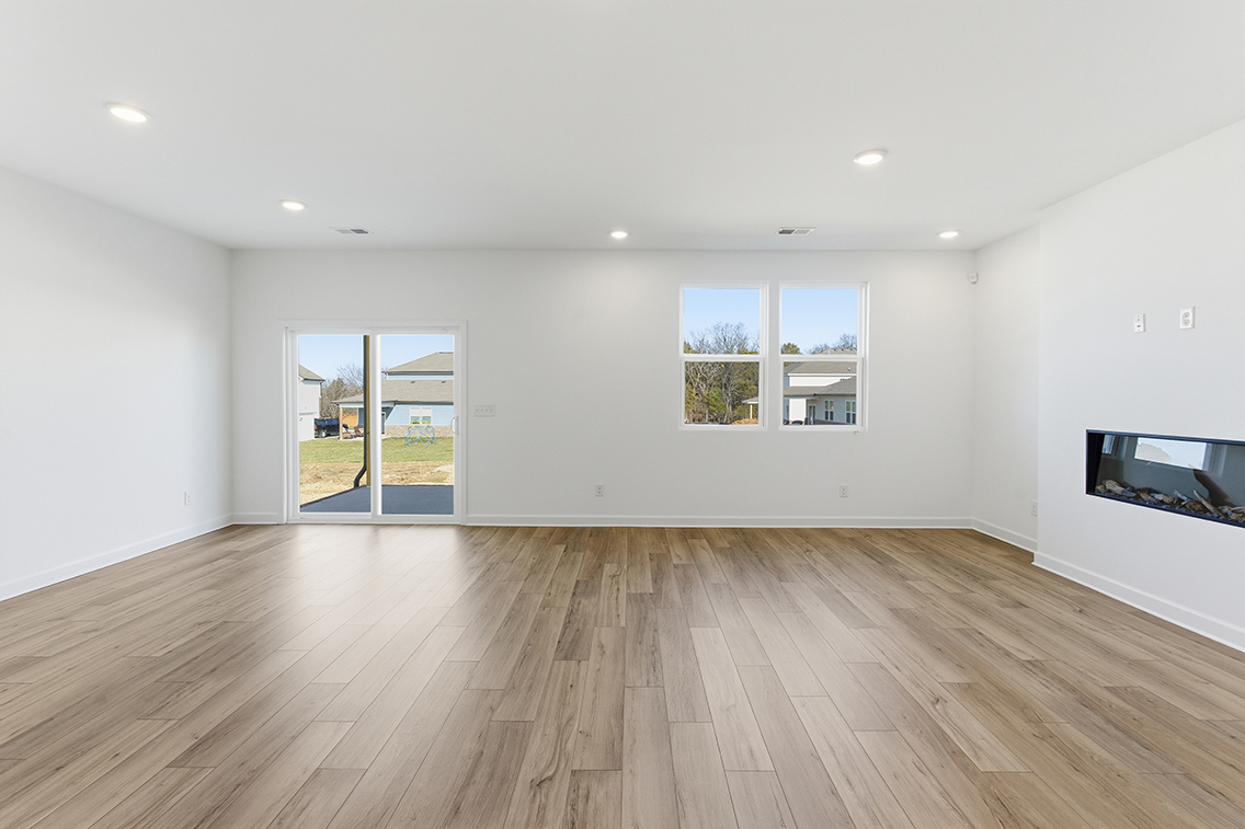 A room with a wood floor and windows.
