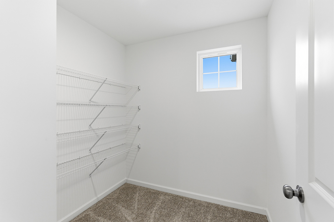 A white wall with a window and a white door.