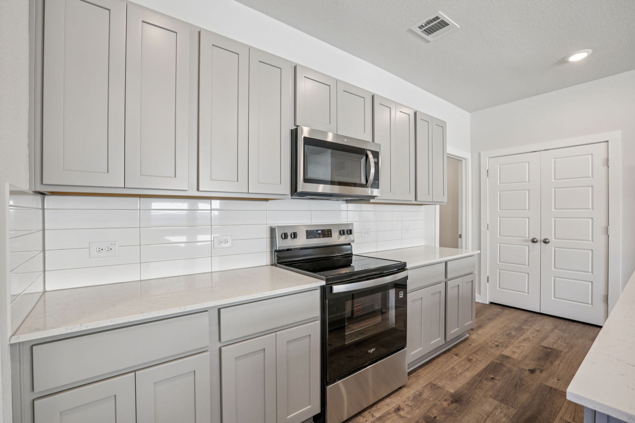 A kitchen with white cabinets.