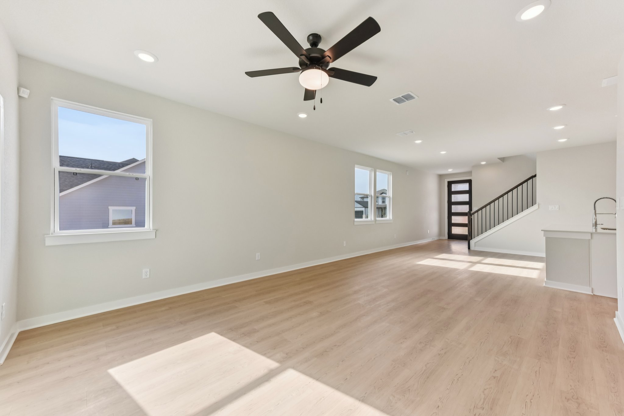A room with a wood floor and a ceiling fan.