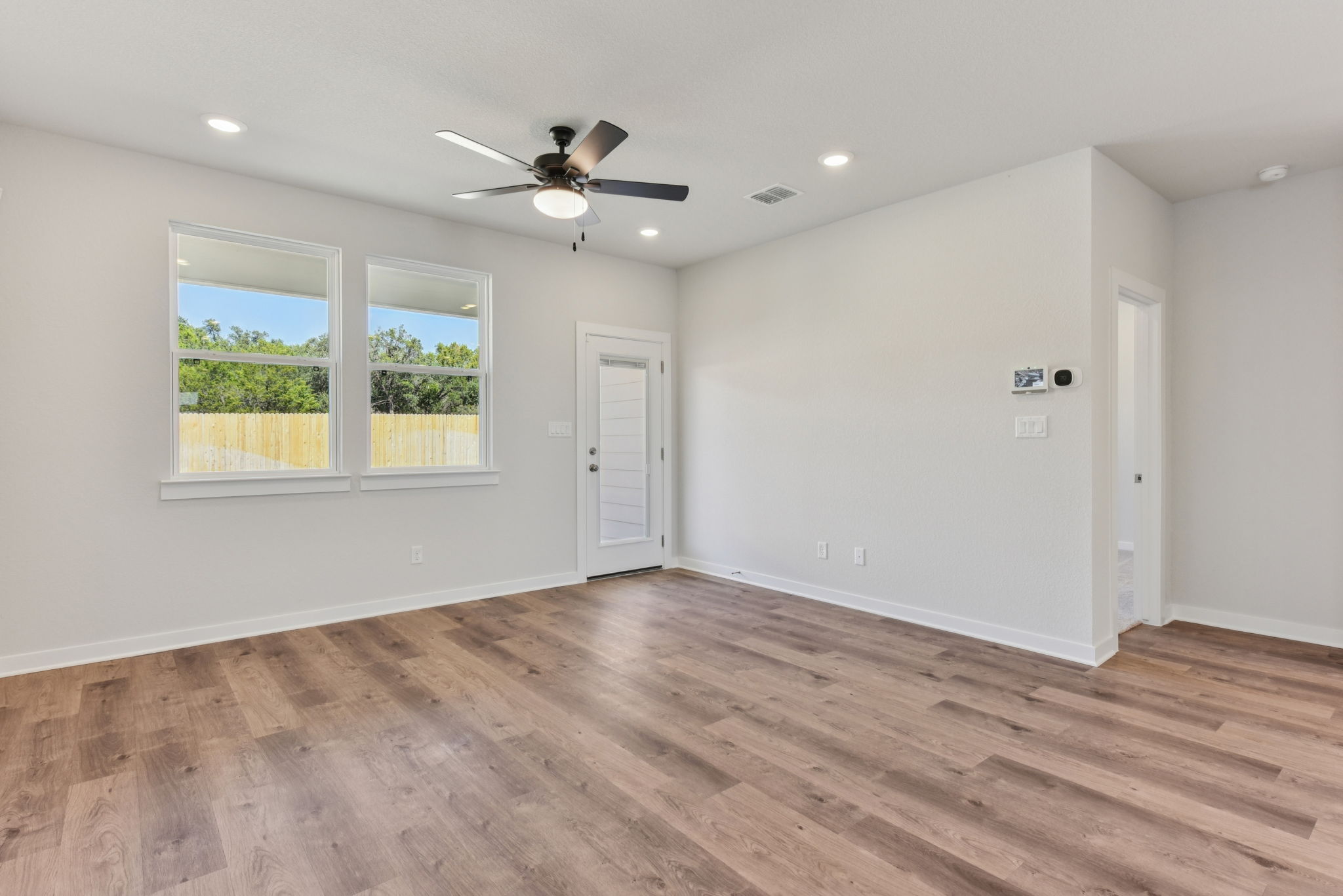 A room with a wood floor and a ceiling fan.