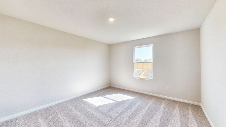 A room with a window and a rug.
