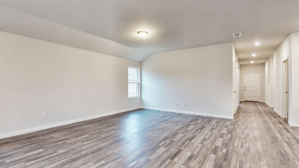 A room with a wood floor and white walls.