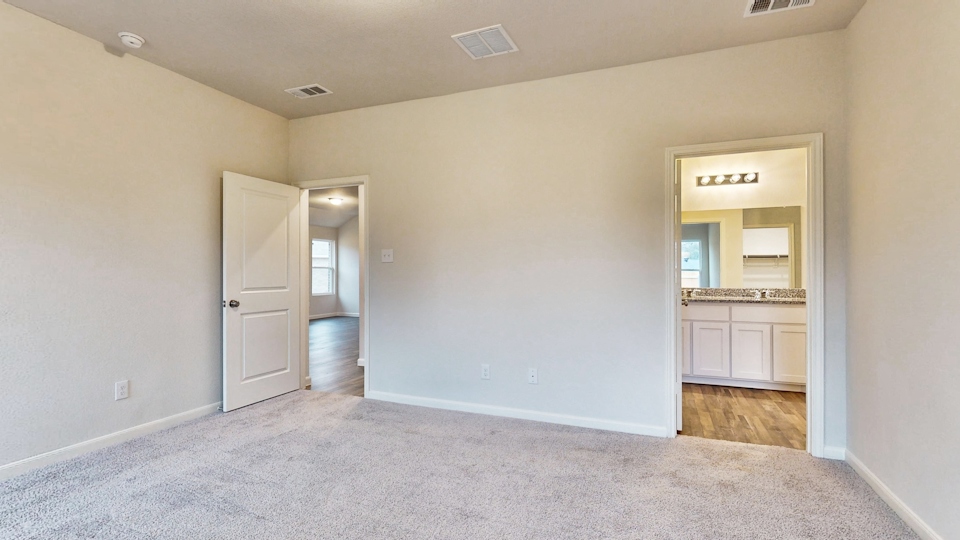 A room with a carpet and a mirror.