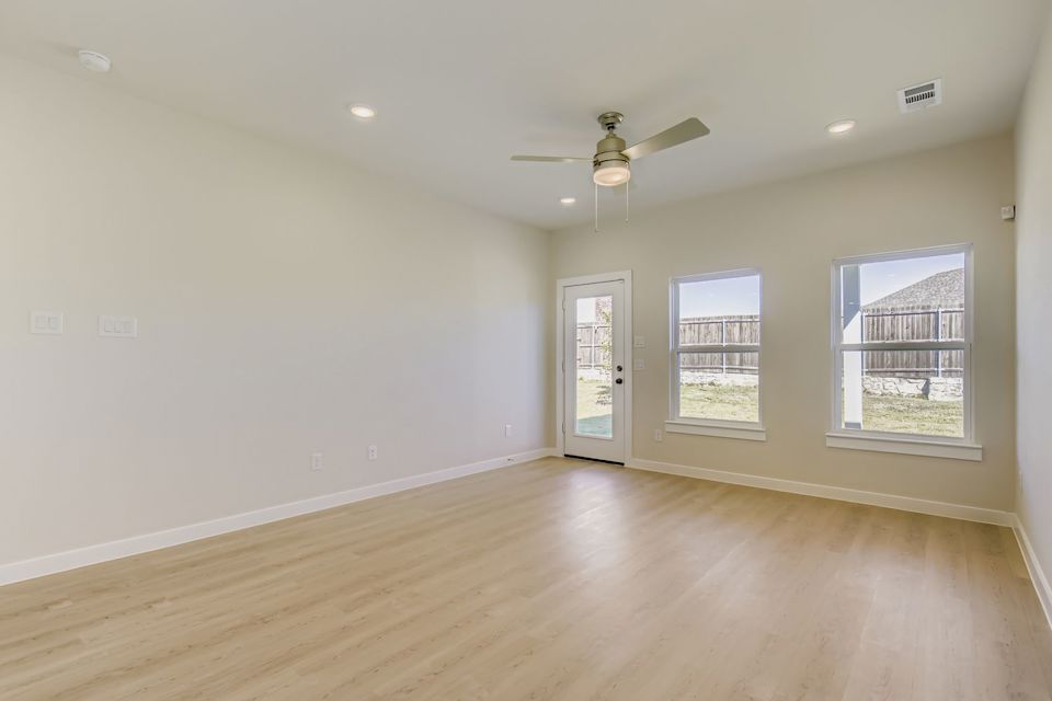 A room with a wood floor and a ceiling fan.