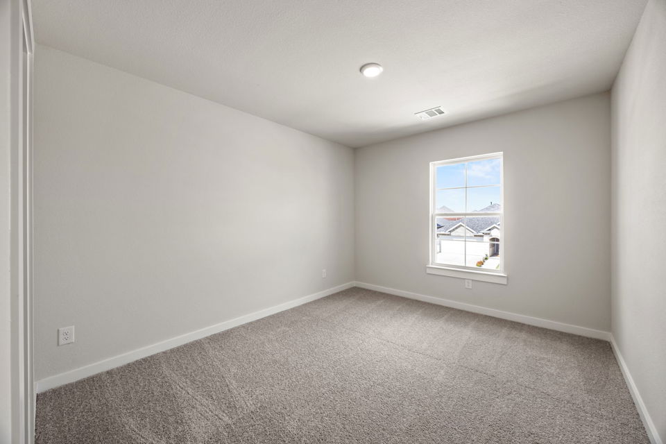 A room with a window and carpet.