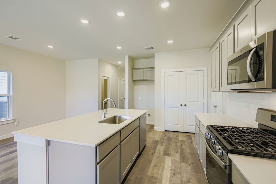 A kitchen with white cabinets.