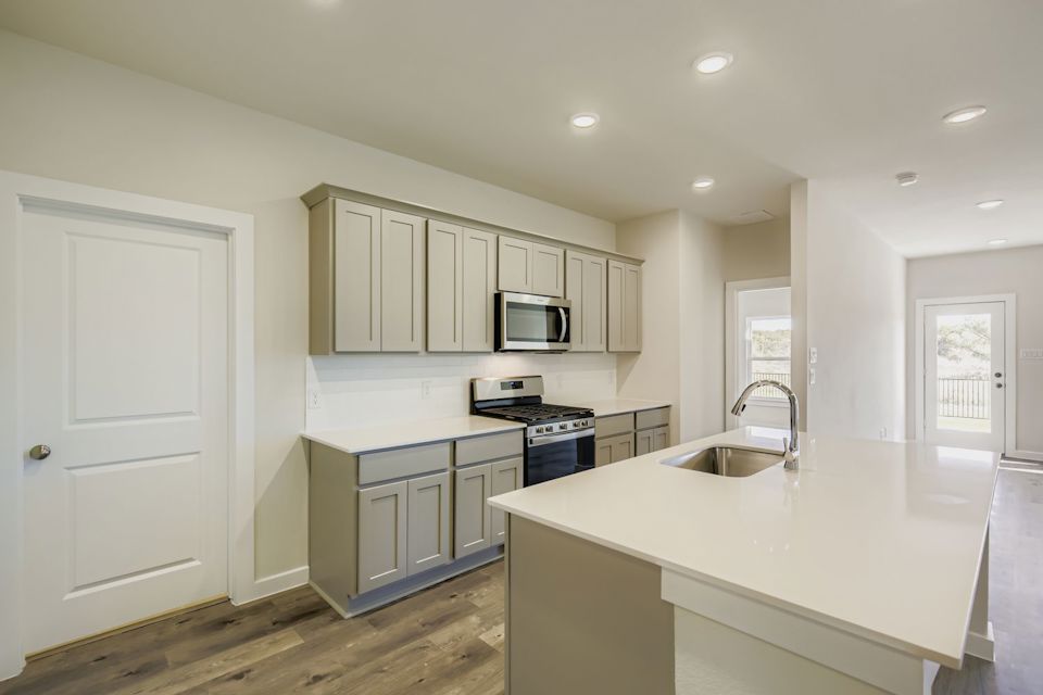 A kitchen with white cabinets.