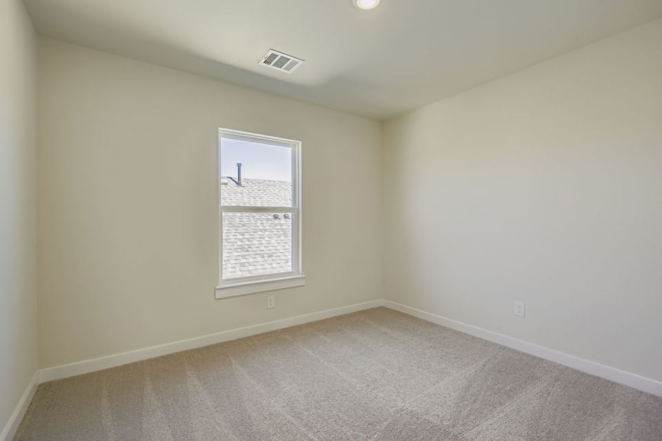 A room with a window and a carpet.