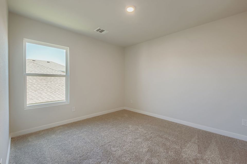 A room with a carpet and a window.