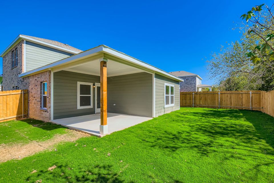 A house with a fence and grass.