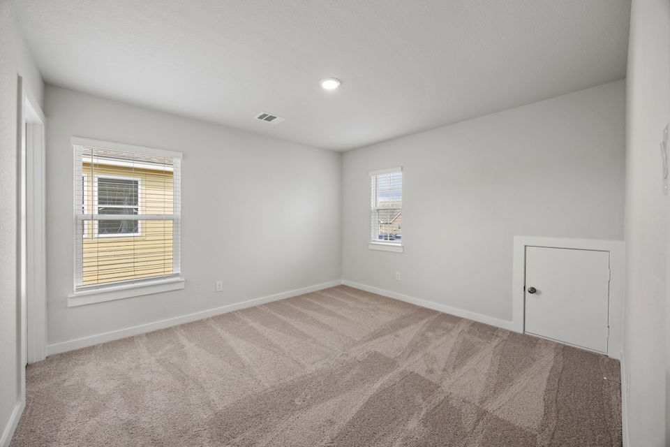 A room with a carpet and a window.
