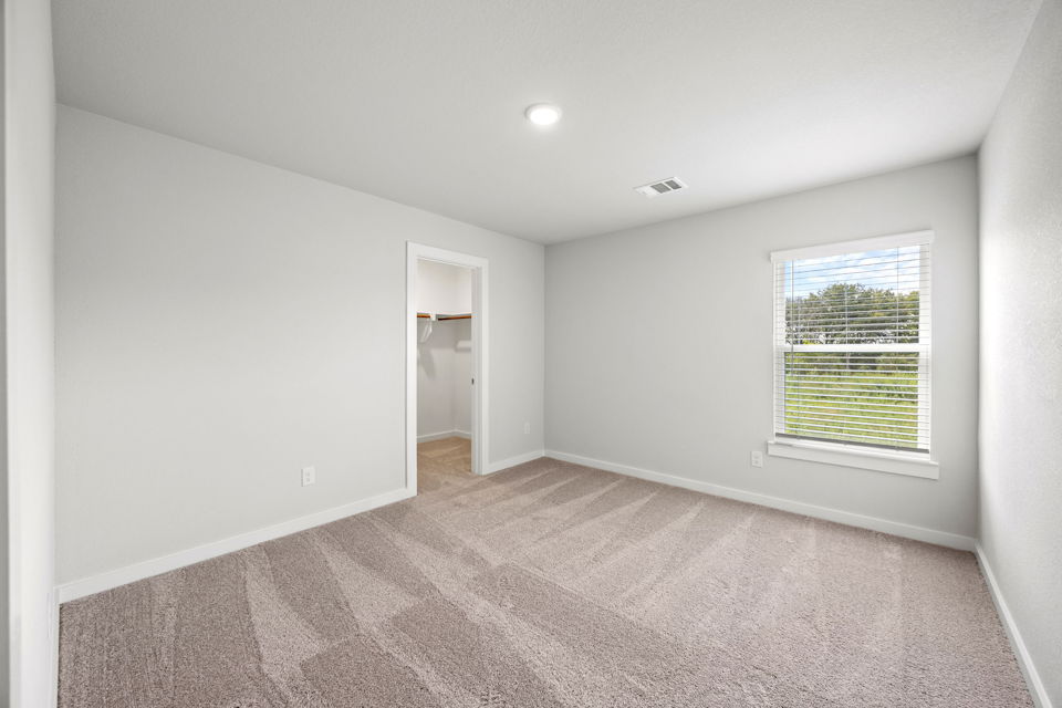 A room with a carpet and a window.