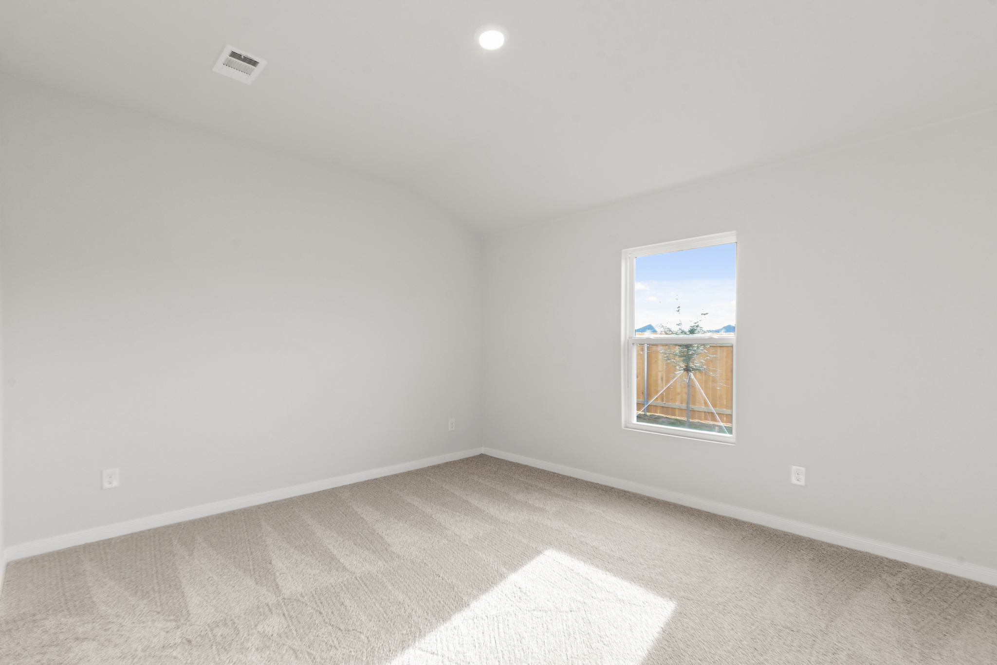 A room with a window and a rug.