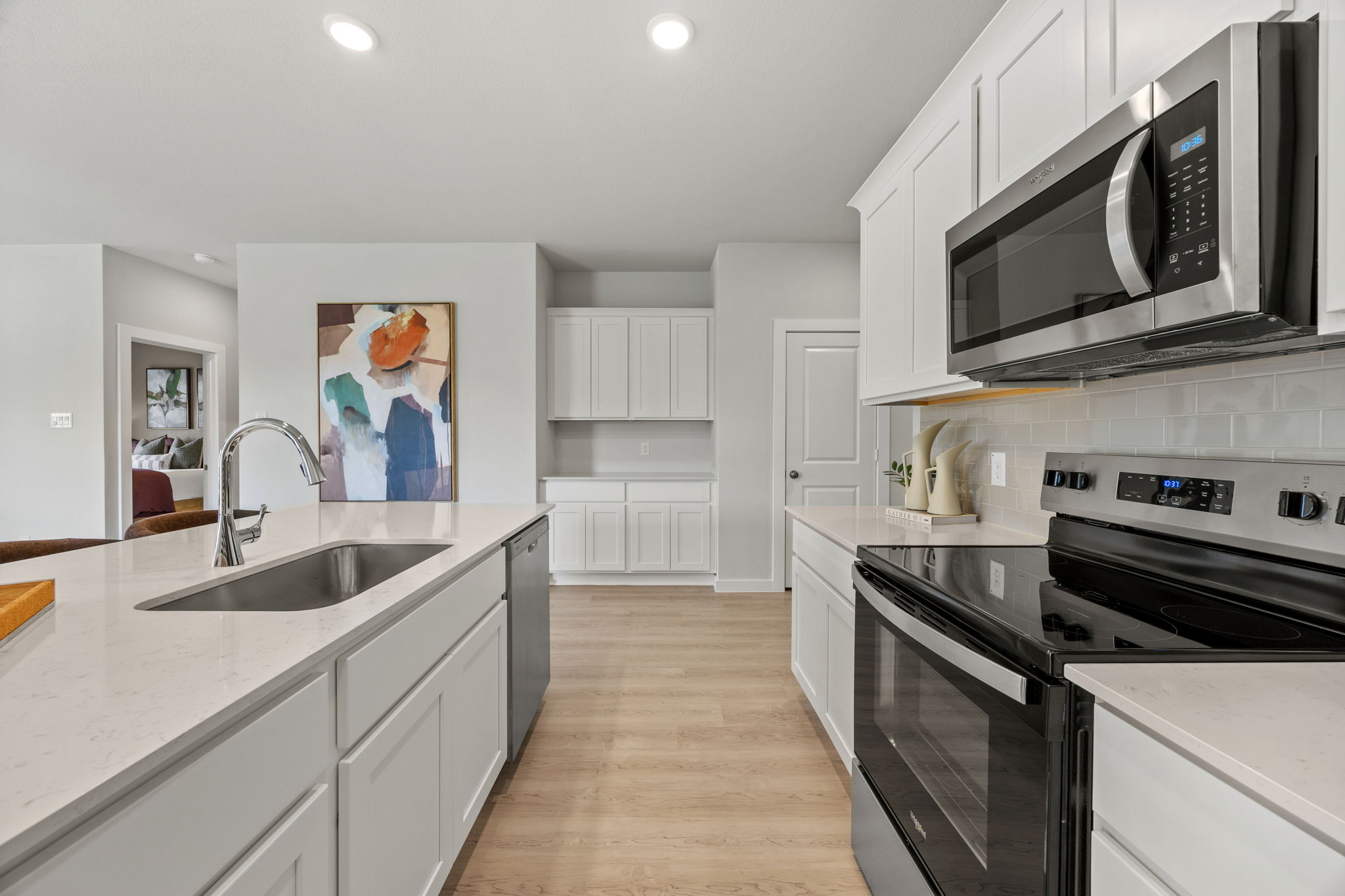 A kitchen with white cabinets.