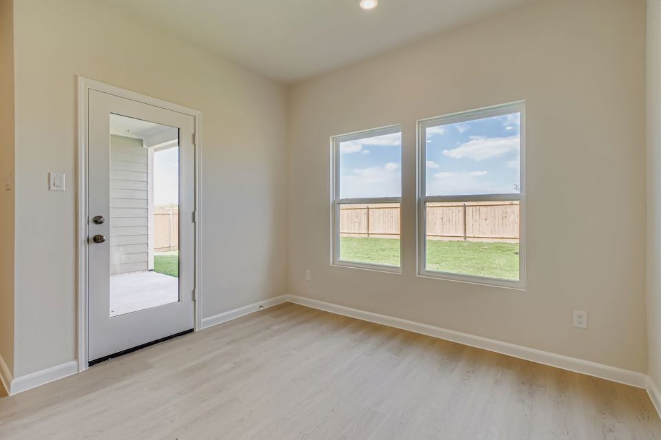 A room with a wood floor and a window with a view of the water.