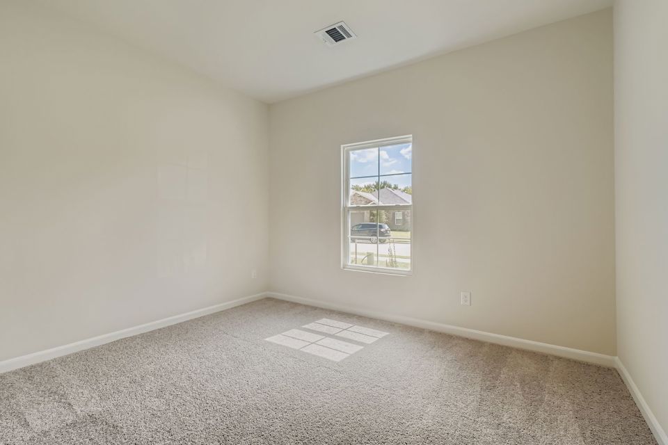 A room with a window and a rug.