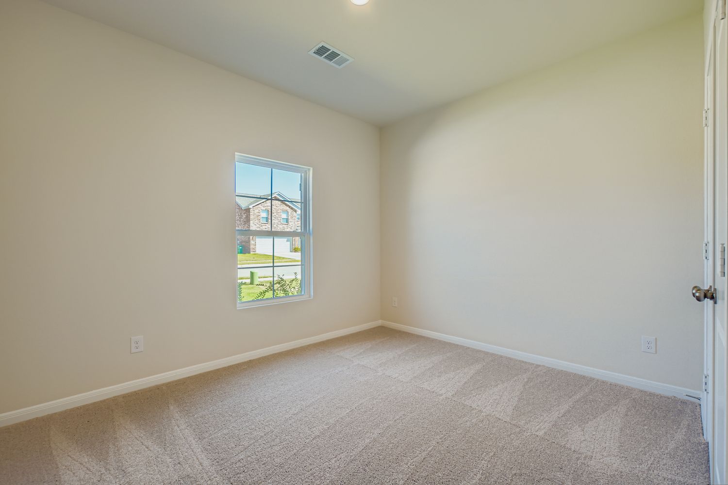 A room with a window and a carpet.
