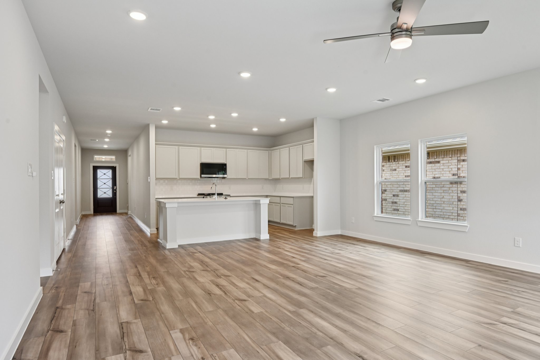 A large empty room with a wood floor and white walls.