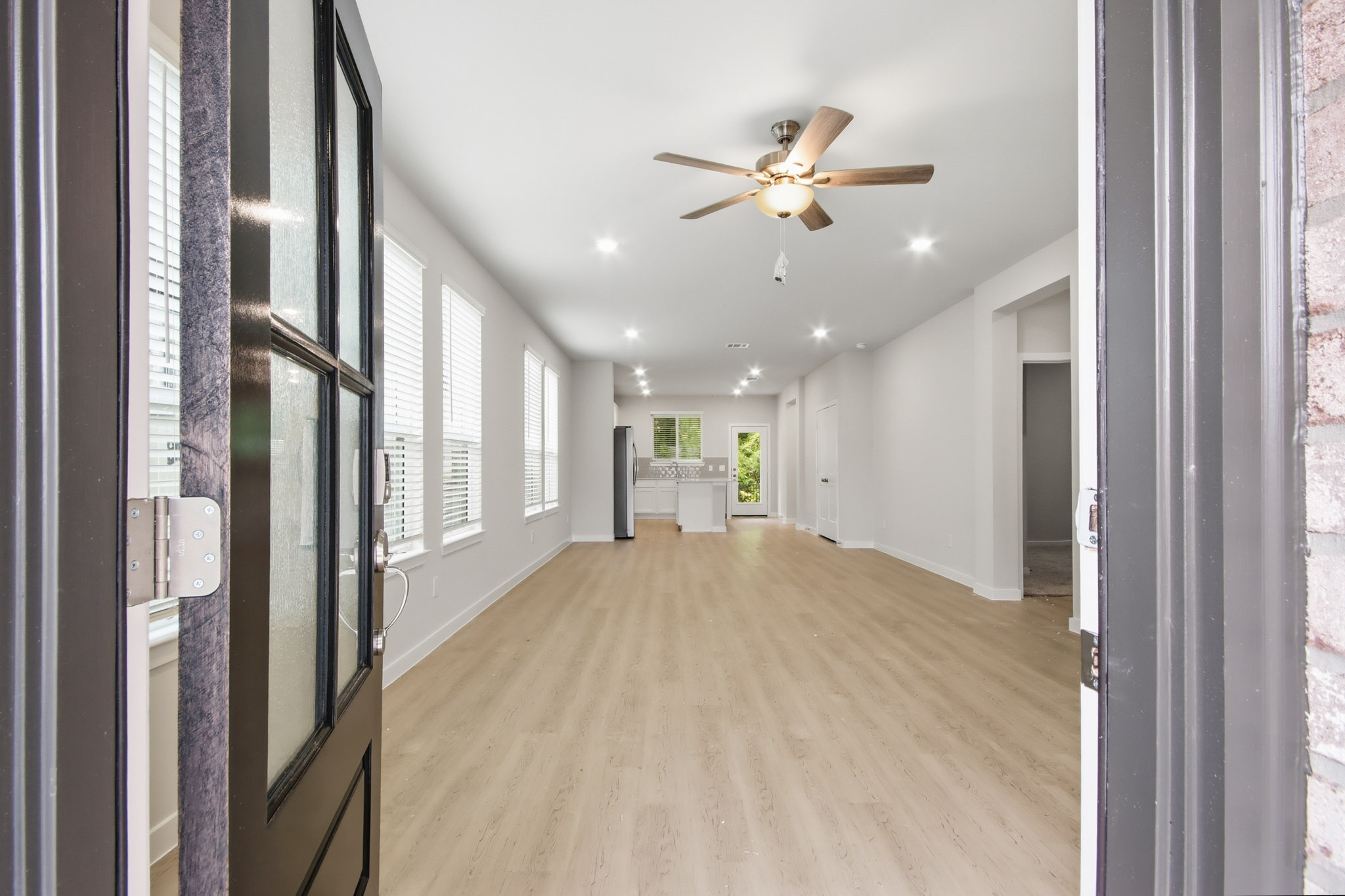 A hallway with a ceiling fan.