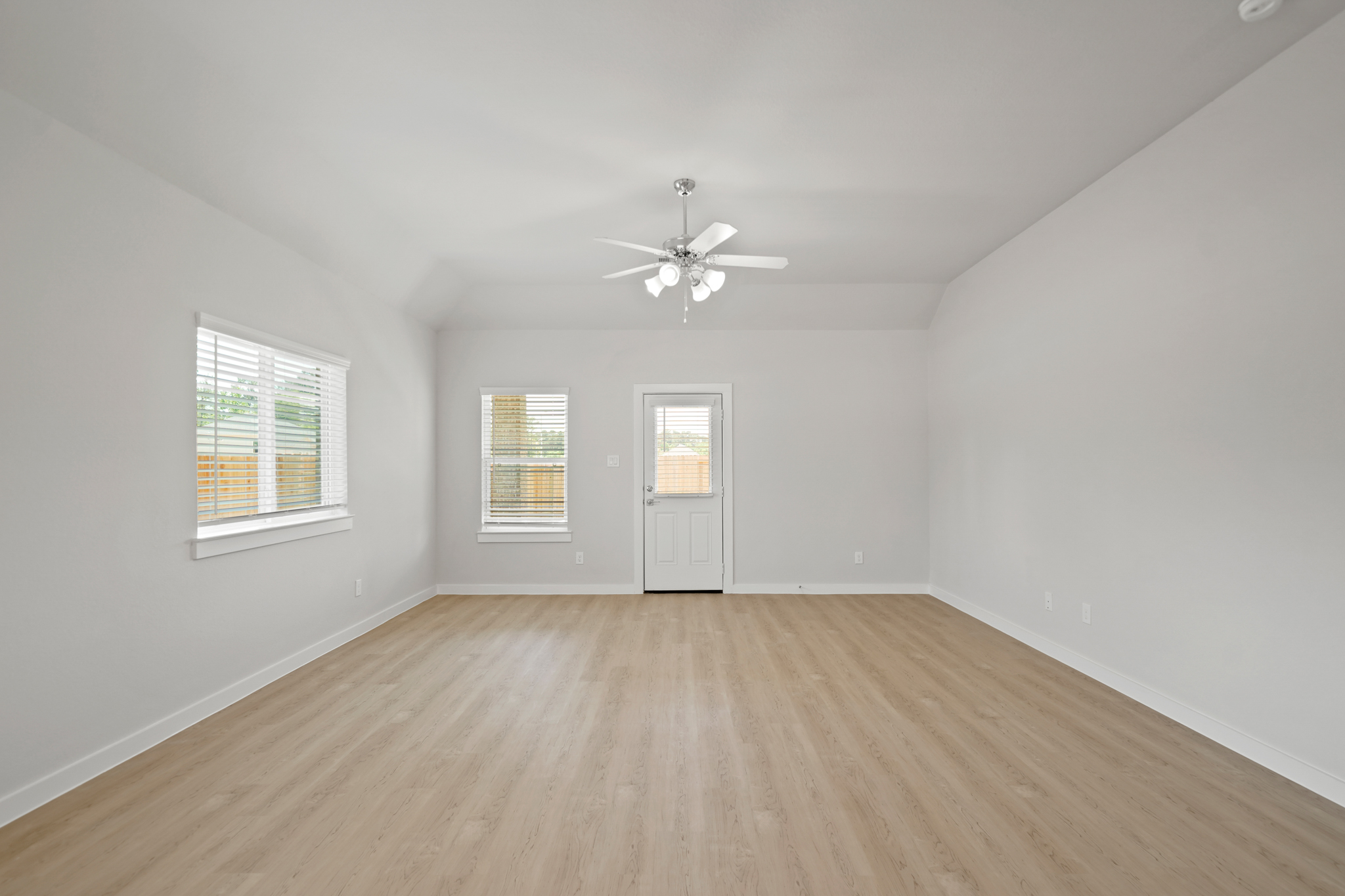 A room with a ceiling fan and a wood floor.