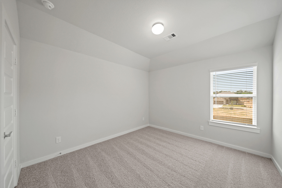A room with a window and a light on the ceiling.