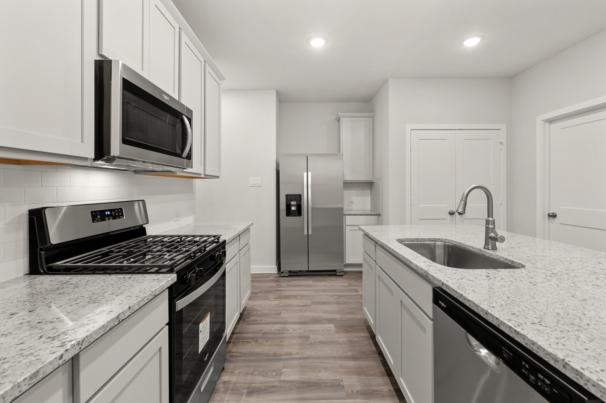 A kitchen with white cabinets.