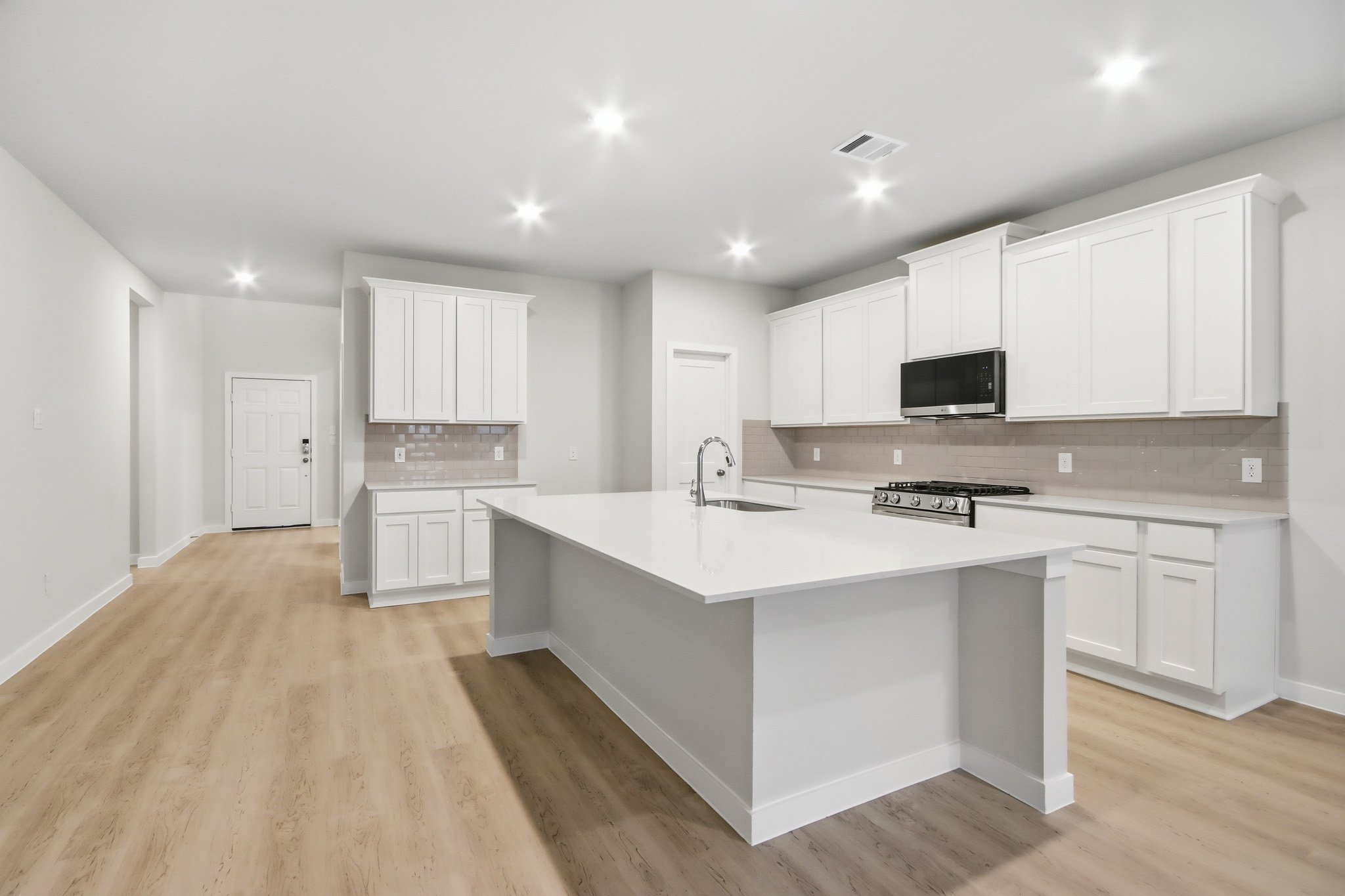 A kitchen with white cabinets.