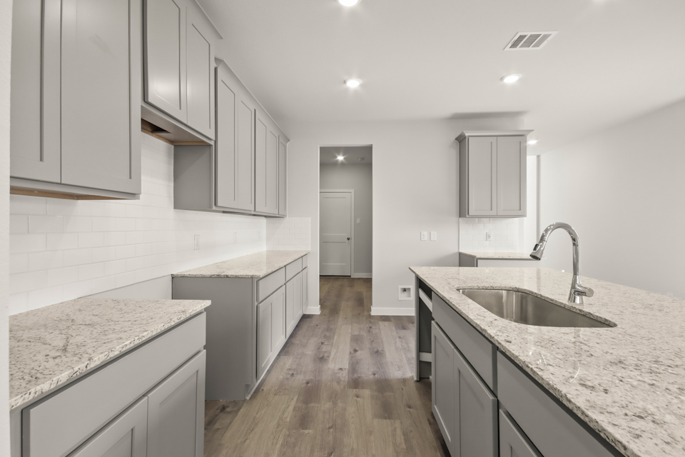 A kitchen with white cabinets.