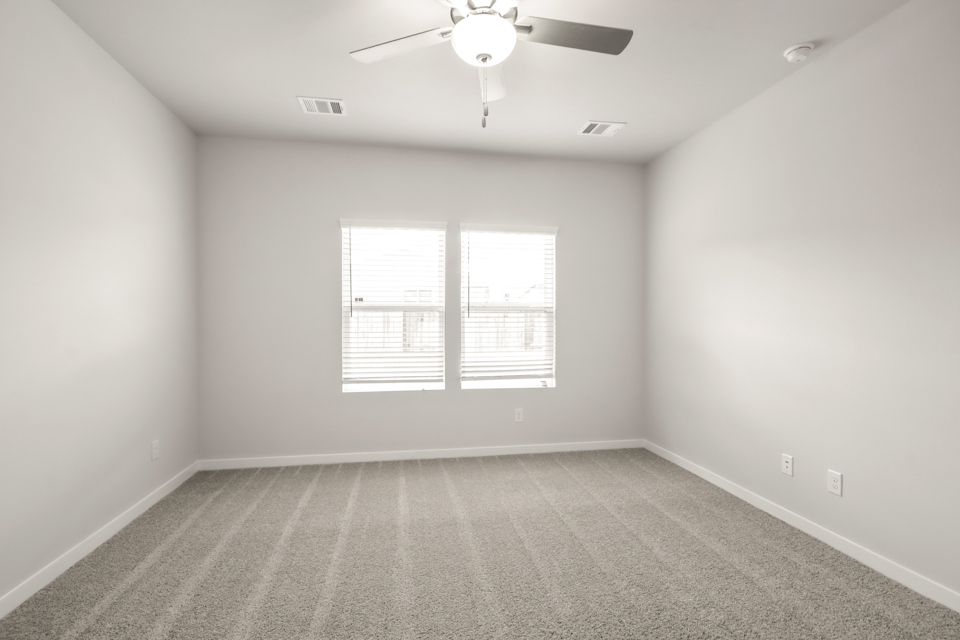 A room with a ceiling fan and a window.