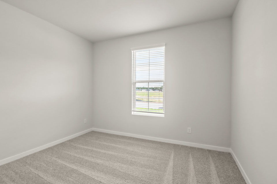 A room with a window and a rug.