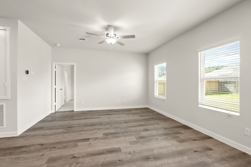 A room with a wood floor and a ceiling fan.