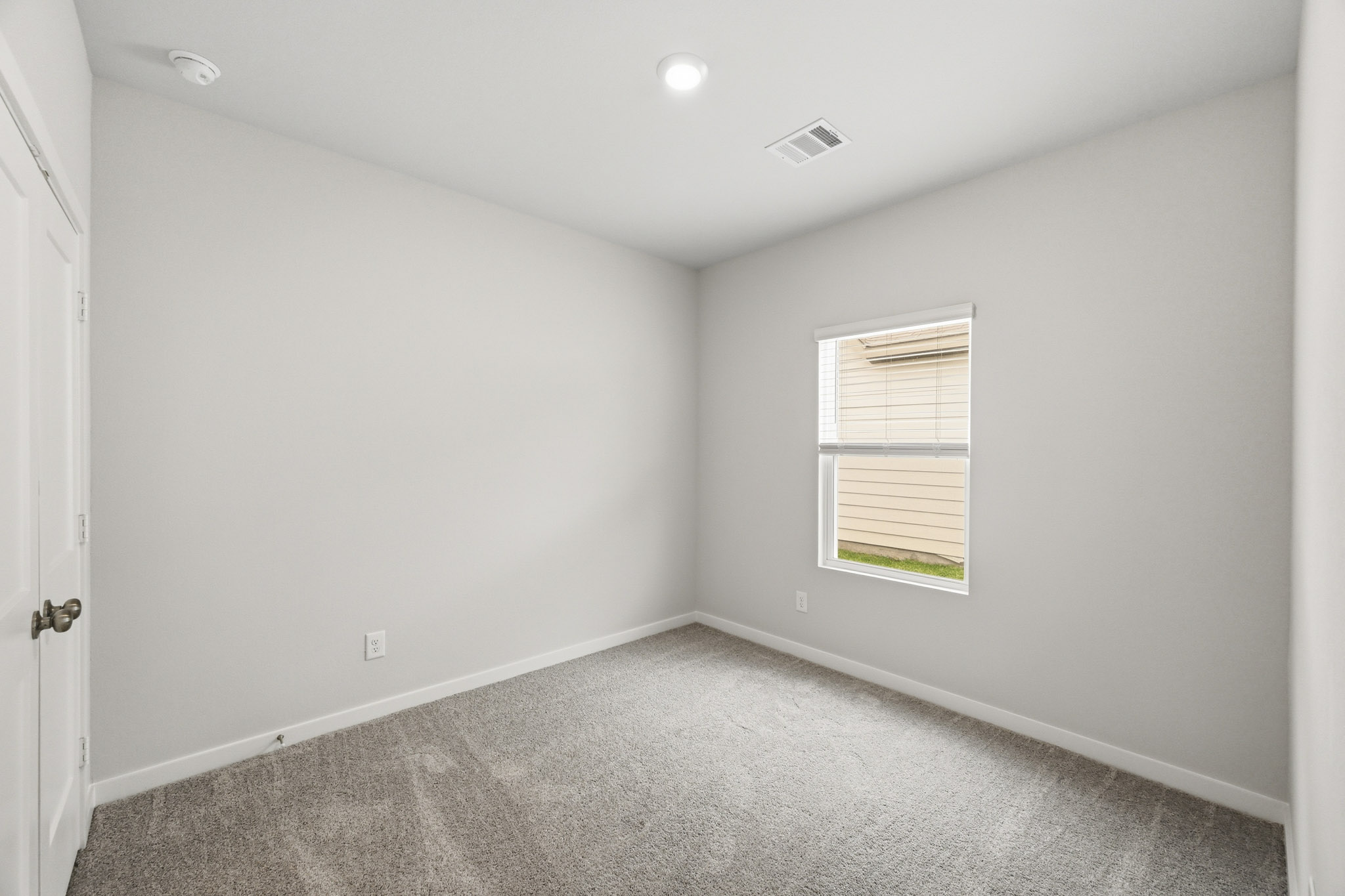 A room with a window and a carpet.