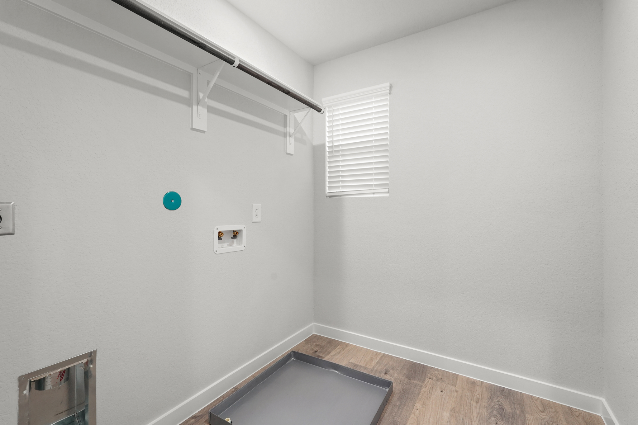 A room with a wood floor and a white wall with a green circle.