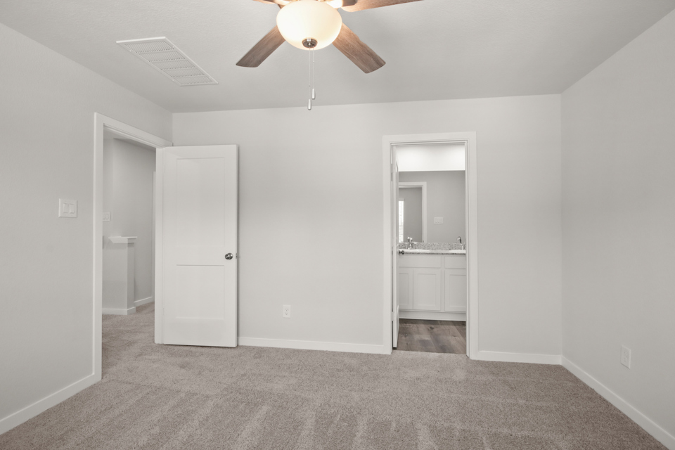 A room with white walls and a ceiling fan.