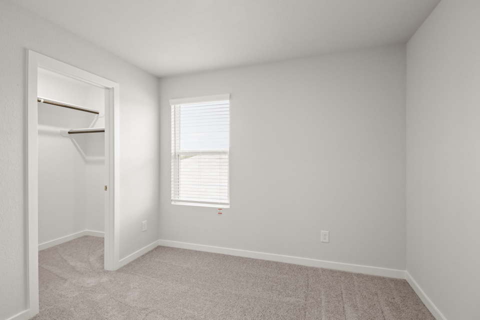 A room with a window and a shelf.