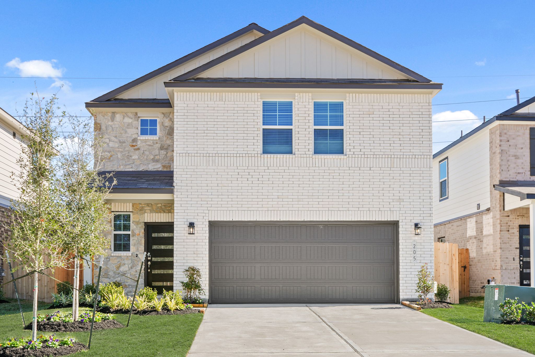 A grey house with a garage.