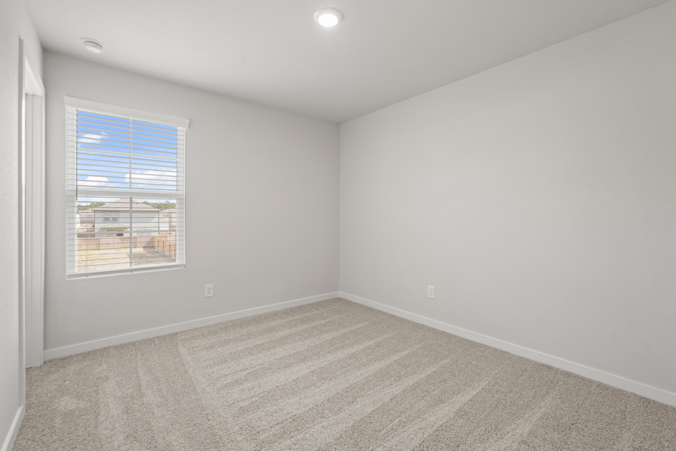 A room with a window and a rug.