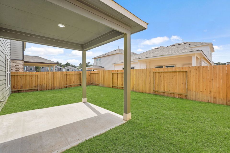 A fenced in yard with a wood fence and a wood fence.