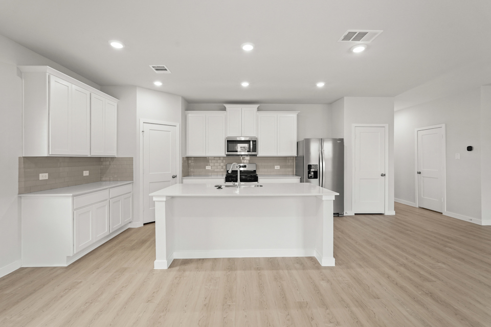 A kitchen with white cabinets.