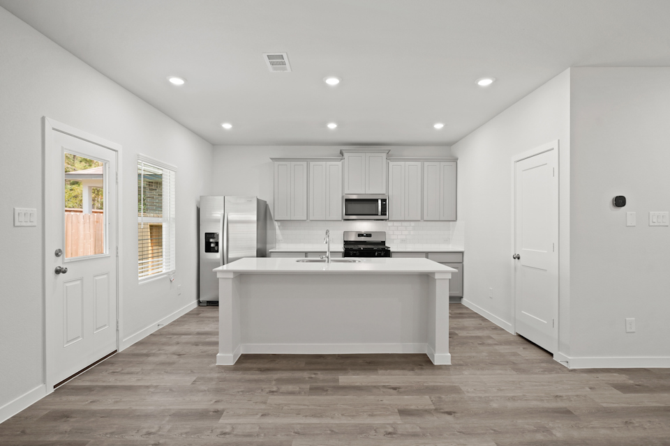 A kitchen with white cabinets.
