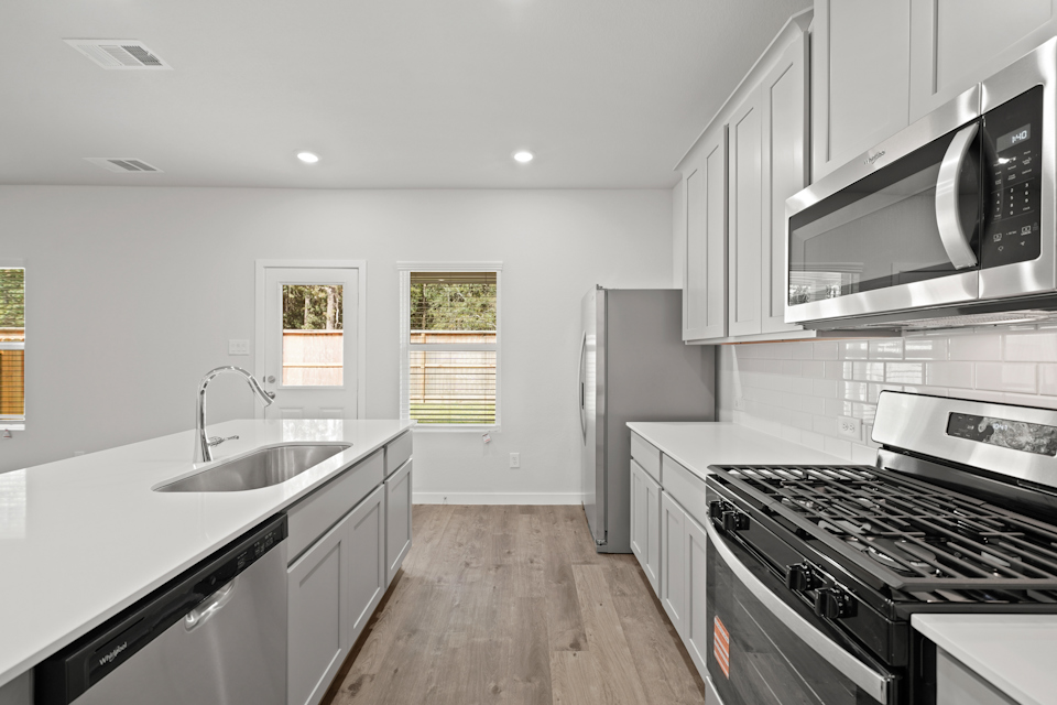 A kitchen with white cabinets.