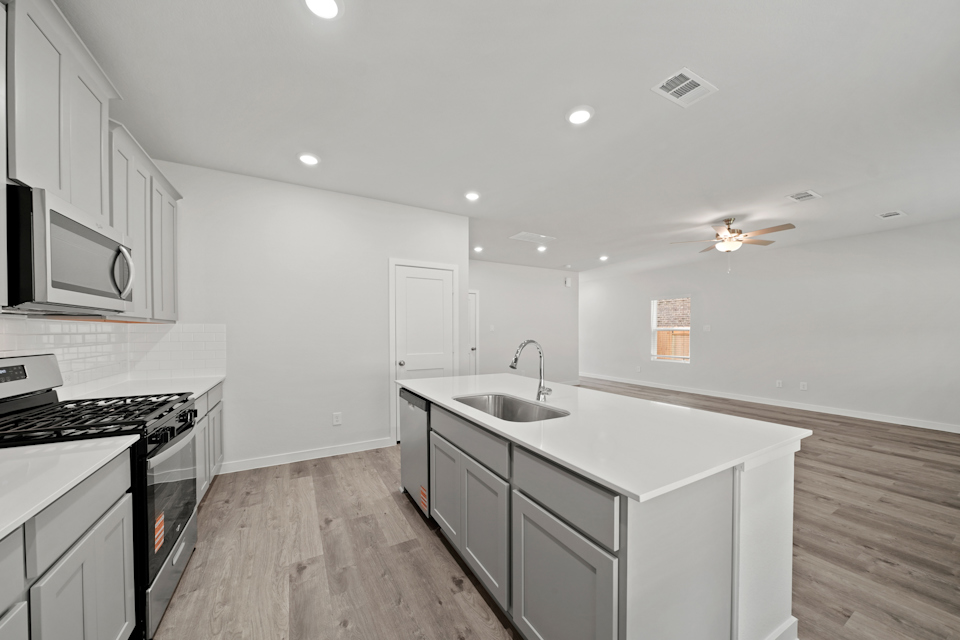 A kitchen with white cabinets.
